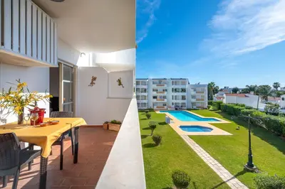 a patio with a table and a yard with a pool at AlgarSun - idealy situated holiday apartment with all modern comfort in Albufeira