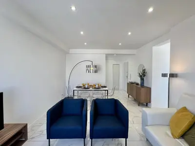 a living room with two blue chairs and a table at Faro Deluxe by Homing in Faro