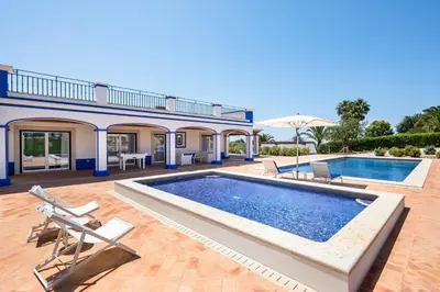 a large swimming pool in a yard with a house at Shantivillas Malhão in Azinhal