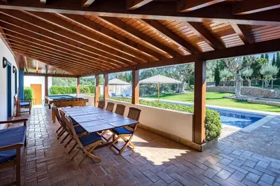 a patio with a table and chairs and a pool at Shantivillas Malhão in Azinhal