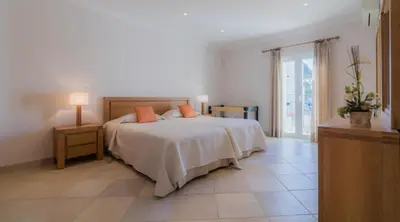 a bedroom with a bed with two orange pillows on it at Villa Bonsal - Modern villa in a prime location near the luxury golf courses in Albufeira
