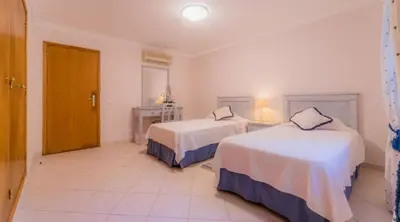 a hotel room with two beds and a door at Villa Bonsal - Modern villa in a prime location near the luxury golf courses in Albufeira