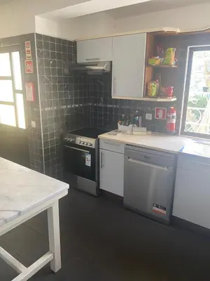 a kitchen with white cabinets and a stove at Villa Amarela in Vilamoura