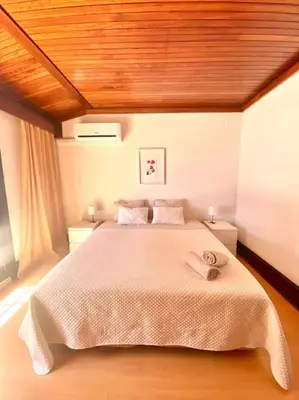 a bedroom with a large bed with a wooden ceiling at Vila Alice in Quarteira