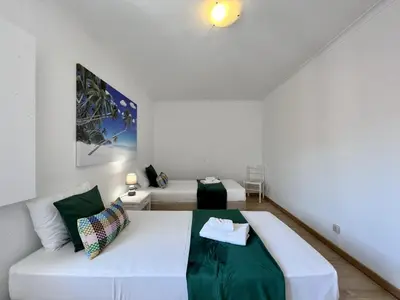 a room with a white bed and a couch at Vilamoura Central 5 by Homing in Vilamoura