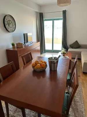 a dining room table with a bowl of oranges on it at Marina de Albufeira T2 até 6 pax Com Piscina e Vista Marina in Albufeira