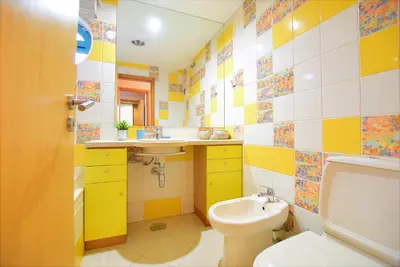 a yellow and white bathroom with a sink and a toilet at Marina de Albufeira T2 até 6 pax Com Piscina e Vista Marina in Albufeira