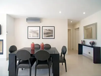 a dining room with a black table and chairs at Apartment Pine Hills Turquesa by Interhome in Vilamoura