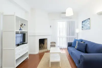a living room with a blue couch and a fireplace at Bright 2BR Apartment with Private Balcony - Albufeira Beach, by Hopstays in Albufeira