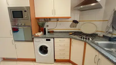 a kitchen with a washing machine and a sink at Your house at Falésia in Albufeira