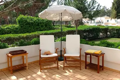 two chairs and an umbrella on a patio at Your house at Falésia in Albufeira