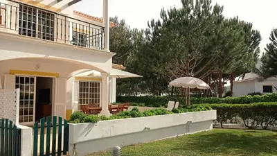 a house with a fence and an umbrella at Your house at Falésia in Albufeira