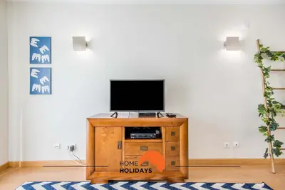 a living room with a tv on a wooden cabinet at #032 T2 Idalia by Home Holidays in Albufeira