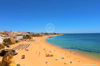 a beach with a lot of people and the ocean at Ocean View Hydrangea - 2 Bedroom Apartment at São Rafael Beach, Albufeira in Albufeira