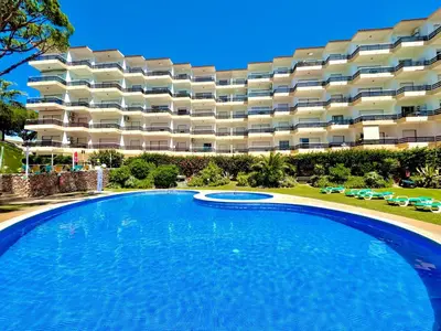 an empty swimming pool in front of a large apartment building at Vilamoura Palm Tree With Pool by Homing in Vilamoura