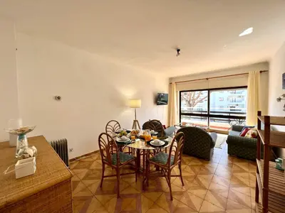 a living room with a table and chairs and a couch at Vilamoura Palm Tree With Pool by Homing in Vilamoura