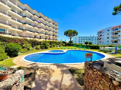 a swimming pool in front of a large apartment building at Vilamoura Palm Tree With Pool by Homing in Vilamoura