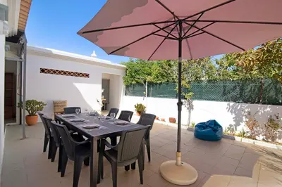 a table with a pink umbrella on a patio at Villa Galé in Guia