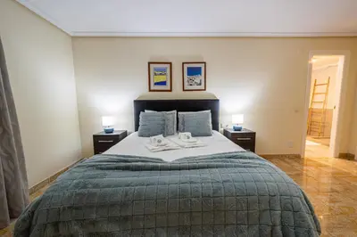 a bedroom with a large bed with two night stands at BeGuest Falésia Pine & Sun Apartment in Albufeira