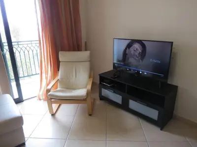 a living room with a tv and a chair at Apartamento - CERRO MAR in Albufeira