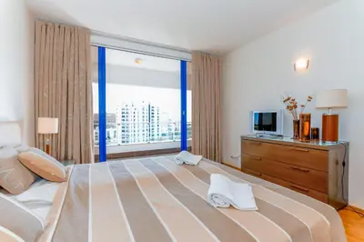 a bedroom with a large bed with a large window at Apartamento Valerie in Vilamoura