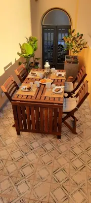 a wooden table with chairs in a living room at Casa da Açoteia - Bright City Center Apartment with a Private Outdoor Terrace in Faro