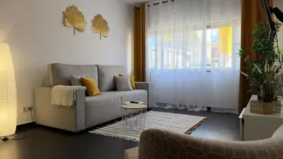 a living room with a couch and a window at Blue Wave Apartment in Albufeira
