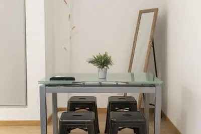 a glass table with three stools under it with a plant at Miral Beachside 1 - by HD Properties in Albufeira