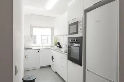 a white kitchen with a microwave and a stove at Miral Beachside 3 - by HD Properties in Albufeira