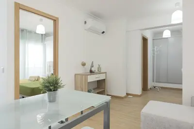 a white living room with a table and a mirror at Miral Beachside 4 - by HD Properties in Albufeira