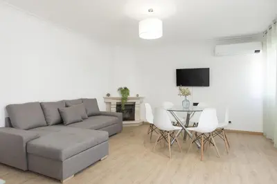 a living room with a couch and a table with chairs at Miral Beachside 5 - by HD Properties in Albufeira