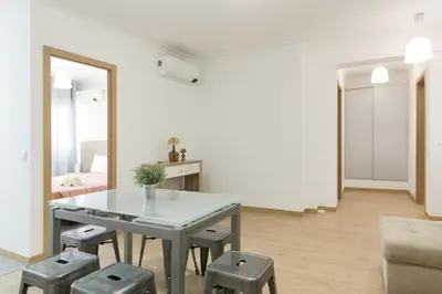 a white living room with a table and stools at Miral Beachside 2 - by HD Properties in Albufeira