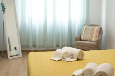 a bedroom with a bed with towels and a chair at Miral Beachside 2 - by HD Properties in Albufeira