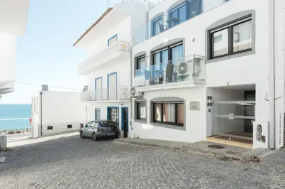 a white building with a car parked in front of it at Miral Beachside 2 - by HD Properties in Albufeira