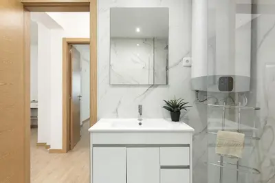 a white bathroom with a sink and a mirror at Miral Beachside 2 - by HD Properties in Albufeira