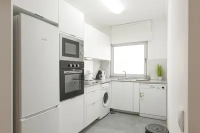 a white kitchen with a microwave and a dishwasher at Miral Beachside 2 - by HD Properties in Albufeira
