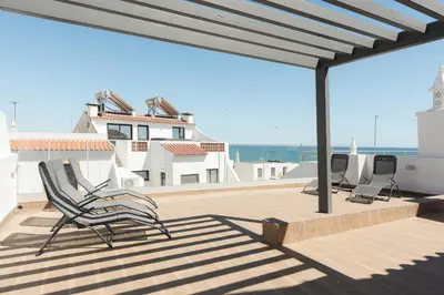 a deck with chairs and a view of the ocean at Miral Beachside 2 - by HD Properties in Albufeira