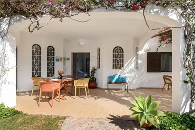 a patio with an archway with a table and chairs at Casa da Oliveira in Loulé