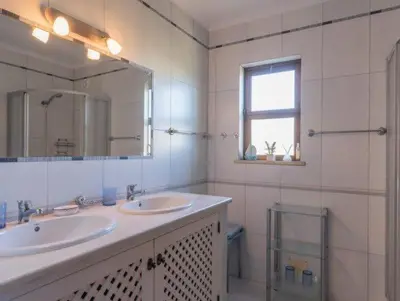 a bathroom with two sinks and a mirror and a window at Villa Savannah - Close to fisherman beach in Albufeira