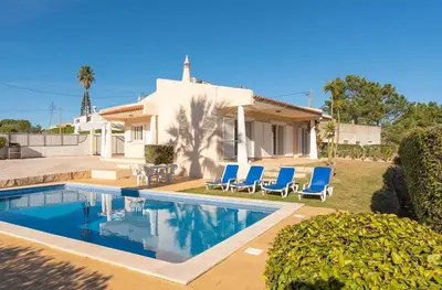 a house with a swimming pool and blue chairs at Villa Castelo Beach - Cosy modern - 500m from Castelo beach in Albufeira