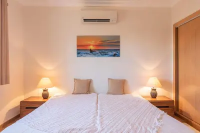 a bedroom with a white bed and two lamps at Villa Castelo Beach - Cosy modern - 500m from Castelo beach in Albufeira