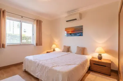 a bedroom with a white bed and a window at Villa Castelo Beach - Cosy modern - 500m from Castelo beach in Albufeira