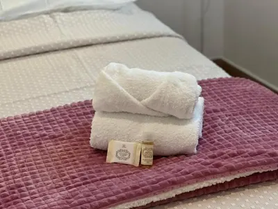 a pair of towels and a bottle of soap on a bed at Casa Sebastião in Faro