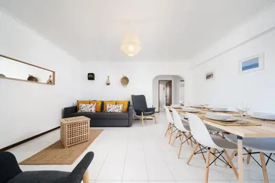 a blue couch with colorful pillows and a white wall at Melvin Jones St. 2bedroom apartment in Quarteira