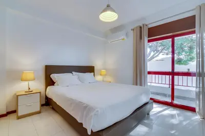 a bedroom with a large white bed and two lamps at Melvin Jones St. 2bedroom apartment in Quarteira