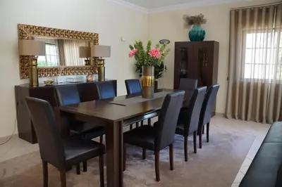 a dining room with a wooden table and black chairs at Villa Selena - Beautiful Luxury villa with massage baths in Quinta do Lago