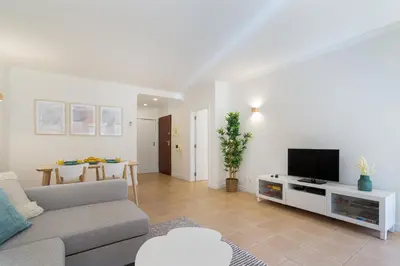 a living room with a couch and a tv at Salgados Sunny Beach Apt - 7 min walk from Beach by Lisbeyond in Guia