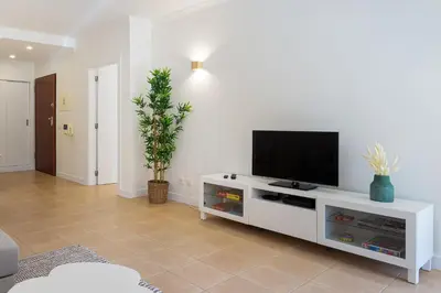 a living room with a tv on a white entertainment center at Salgados Sunny Beach Apt - 7 min walk from Beach by Lisbeyond in Guia
