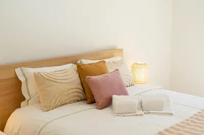 a bed with white sheets and pillows on it at Salgados Sunny Beach Apt - 7 min walk from Beach by Lisbeyond in Guia
