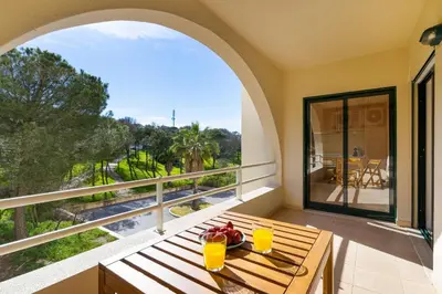 a balcony with a table with two glasses of orange juice at Salgados Sunny Beach Apt - 7 min walk from Beach by Lisbeyond in Guia
